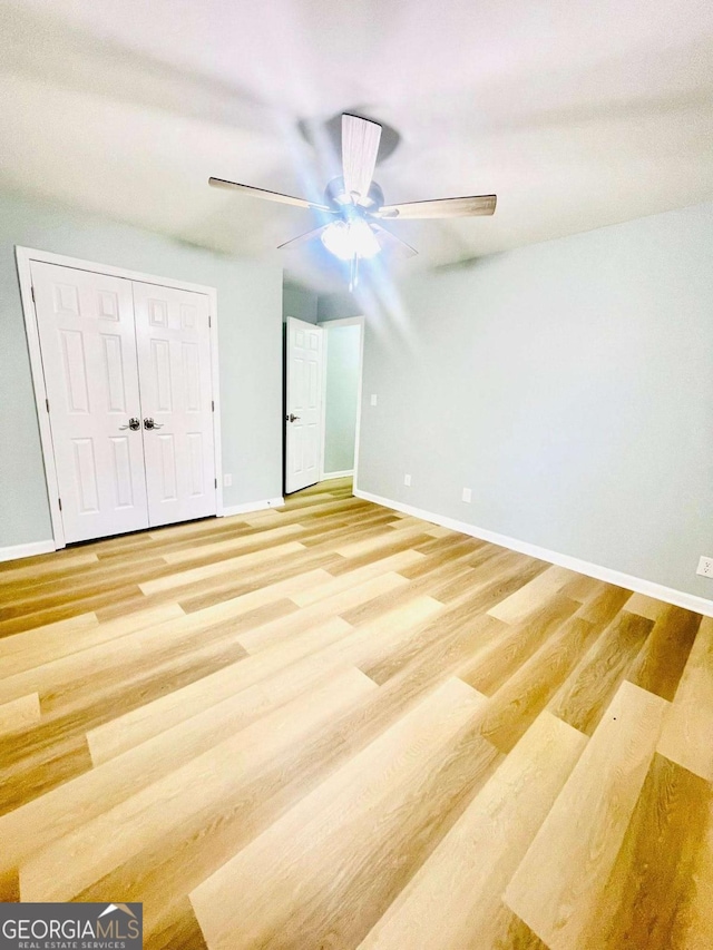 7675 Lanier View Rdg, Cumming, GA 30041 - unfurnished bedroom with light wood-style flooring, baseboards, a ceiling fan, and a closet