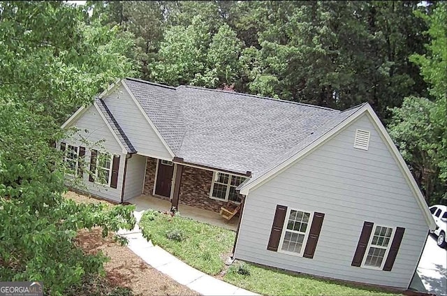 7675 Lanier View Rdg, Cumming, GA 30041 - view of front of house with a patio, stone siding, and a shingled roof