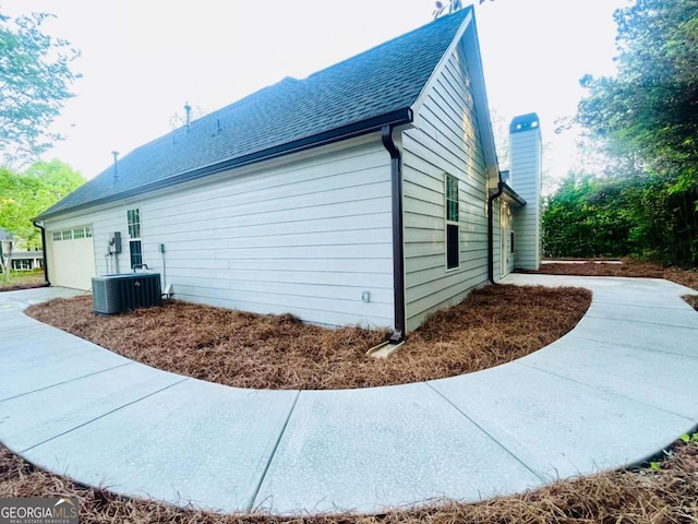 7675 Lanier View Rdg, Cumming, GA 30041 - view of side of property with an attached garage, a chimney, and a shingled roof