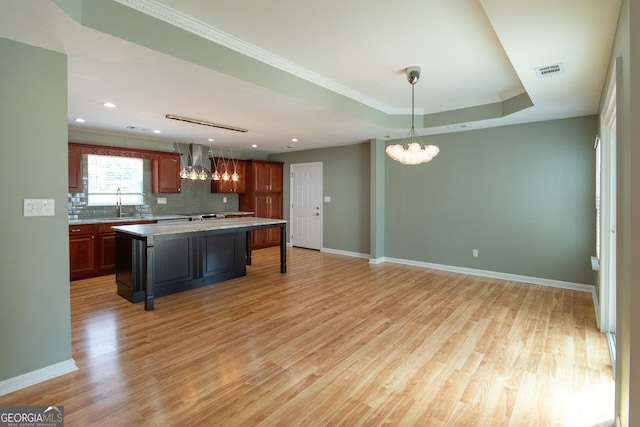 5 Gibson Rd, Newnan, GA 30263 - kitchen featuring a chandelier, wall chimney exhaust hood, light wood-style floors, tasteful backsplash, and ornamental molding