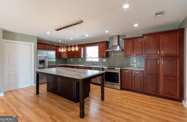 5 Gibson Rd, Newnan, GA 30263 - kitchen with wall chimney range hood, stainless steel appliances, decorative backsplash, light wood finished floors, and recessed lighting