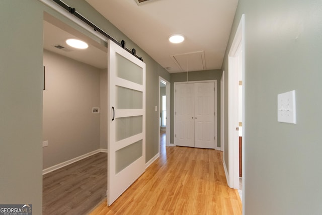 5 Gibson Rd, Newnan, GA 30263 - hall with light wood-style flooring, a barn door, baseboards, and attic access