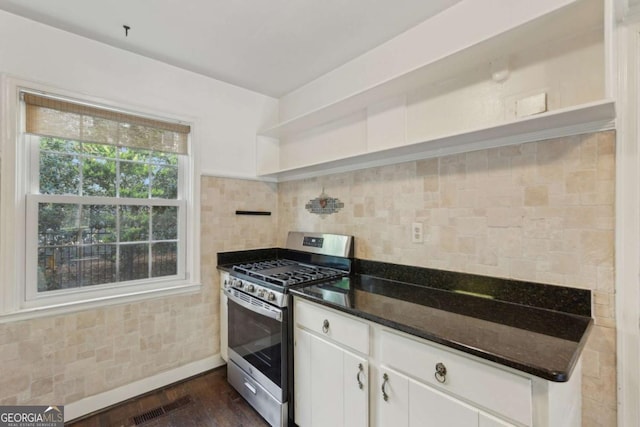 55 Delmont Dr NE Unit D1, Atlanta, GA 30305 - kitchen featuring stainless steel range with gas cooktop, open shelves, white cabinets, dark stone counters, and decorative backsplash