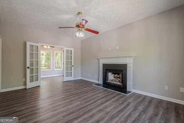 1331 Windage Ct SW, Marietta, GA 30008 - unfurnished living room with french doors, dark wood-type flooring, a ceiling fan, a textured ceiling, and a fireplace with raised hearth