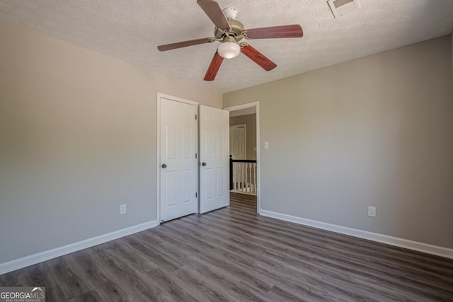 1331 Windage Ct SW, Marietta, GA 30008 - unfurnished bedroom featuring dark wood finished floors, a textured ceiling, and a ceiling fan