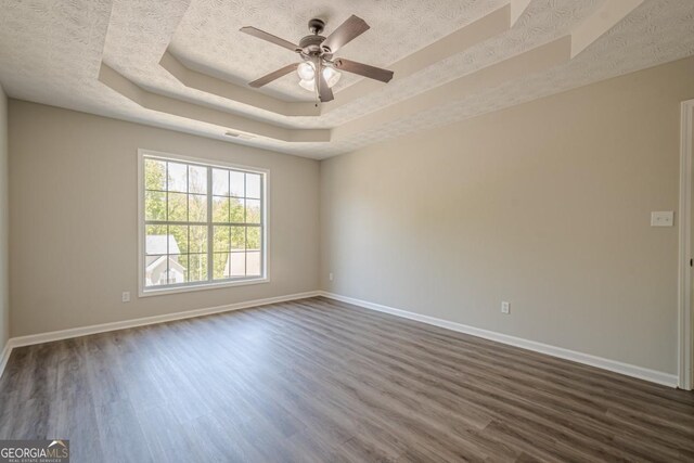 1331 Windage Ct SW, Marietta, GA 30008 - empty room with a tray ceiling, dark wood-type flooring, ceiling fan, and a textured ceiling