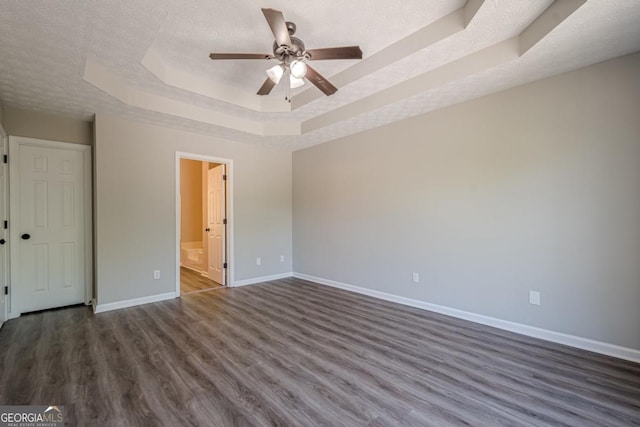 1331 Windage Ct SW, Marietta, GA 30008 - unfurnished bedroom with a raised ceiling, dark wood finished floors, a textured ceiling, connected bathroom, and ceiling fan
