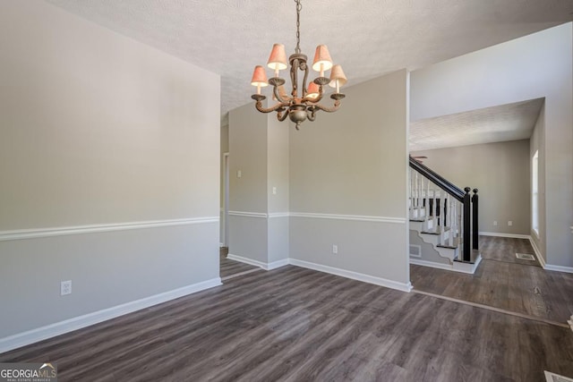1331 Windage Ct SW, Marietta, GA 30008 - unfurnished dining area featuring a chandelier, a textured ceiling, wood finished floors, and stairs