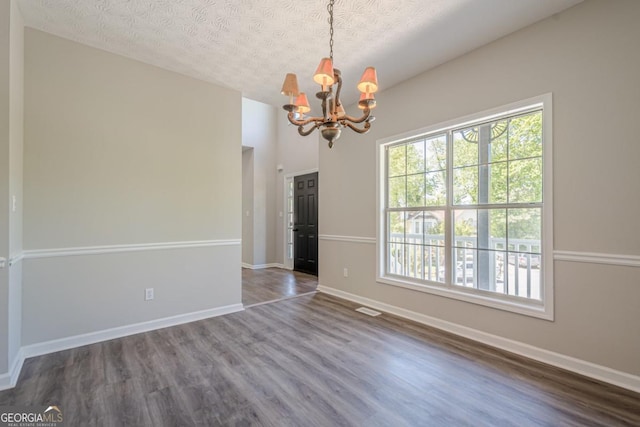 1331 Windage Ct SW, Marietta, GA 30008 - unfurnished dining area featuring a chandelier, wood finished floors, and a textured ceiling