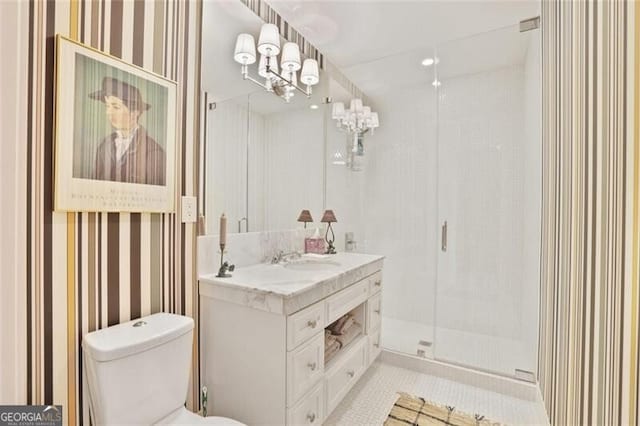 bathroom with a stall shower, vanity, toilet, and wallpapered walls