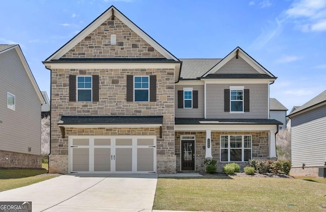 craftsman inspired home featuring an attached garage, driveway, stone siding, roof with shingles, and a front yard