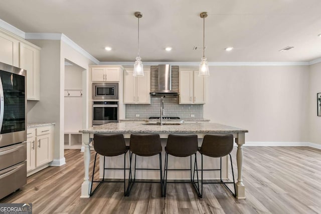 kitchen featuring wall chimney exhaust hood, ornamental molding, appliances with stainless steel finishes, and tasteful backsplash