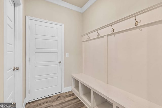 mudroom with crown molding and wood finished floors