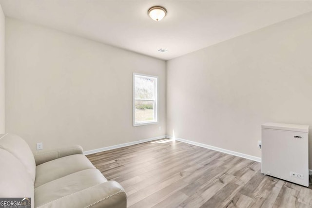unfurnished room with light wood-style flooring, visible vents, and baseboards
