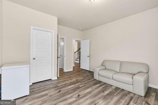 living area with baseboards and wood finished floors