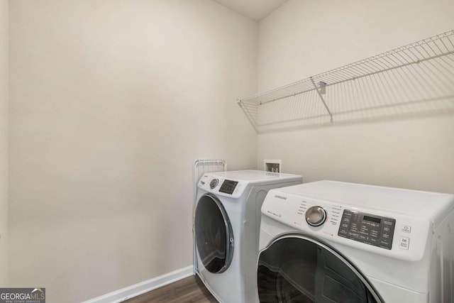 clothes washing area featuring baseboards, dark wood-type flooring, laundry area, and independent washer and dryer