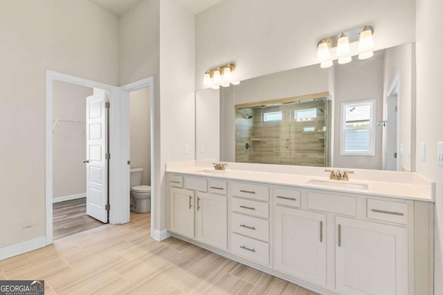 1602 Dover Creek Ln, Lawrenceville, GA 30045 - bathroom with a stall shower, double vanity, a walk in closet, and wood finished floors