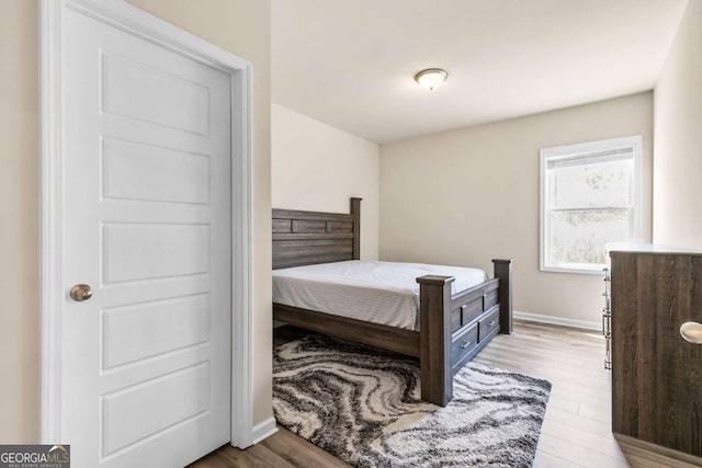 bedroom featuring wood finished floors and baseboards