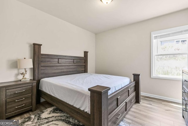 bedroom with light wood finished floors and baseboards