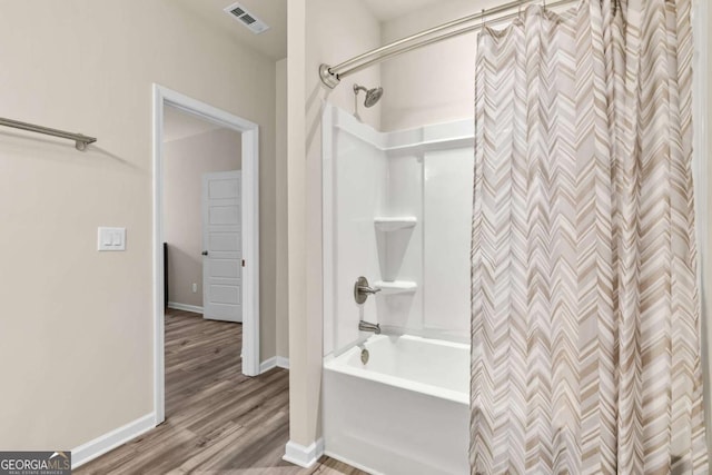 full bath featuring shower / tub combo, baseboards, wood finished floors, and visible vents