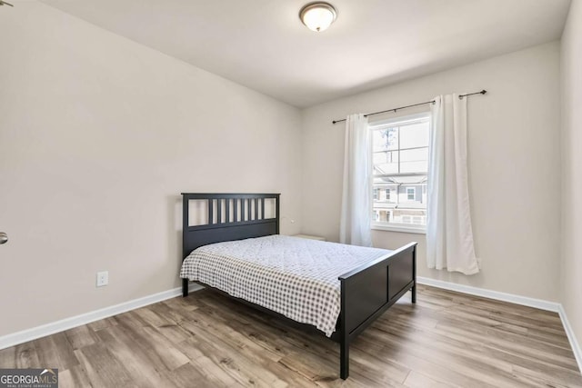 bedroom with baseboards and wood finished floors