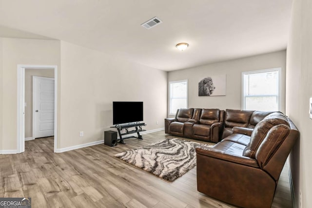 living area featuring wood finished floors, visible vents, and baseboards