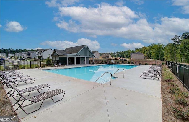 community pool with fence and a patio