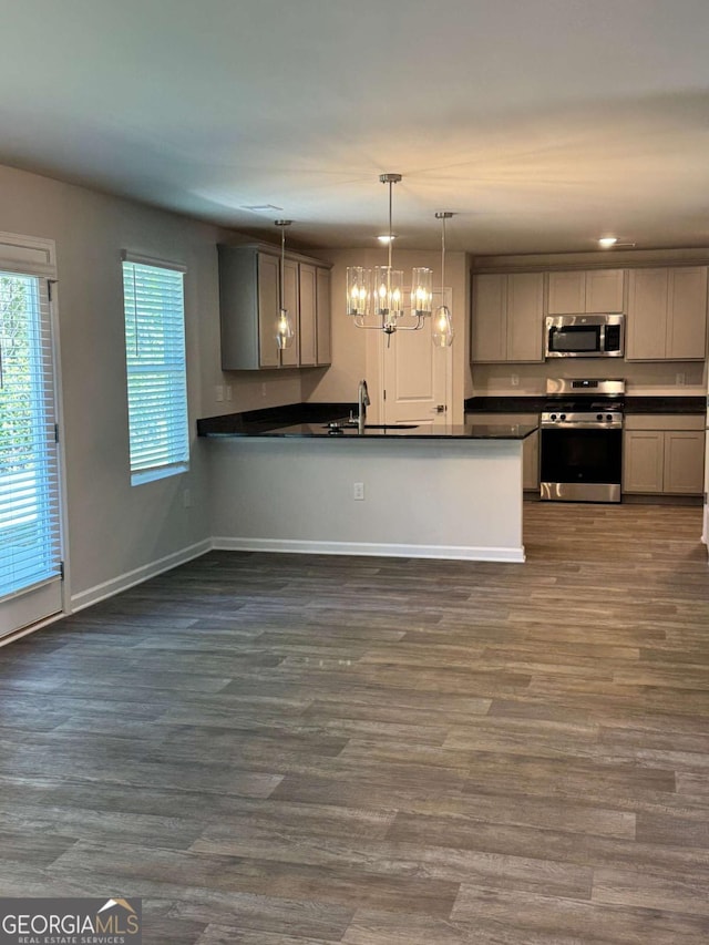 124 Shenandoah Ln, Lagrange, GA 30241 - kitchen with stainless steel appliances, a sink, dark wood finished floors, dark countertops, and baseboards