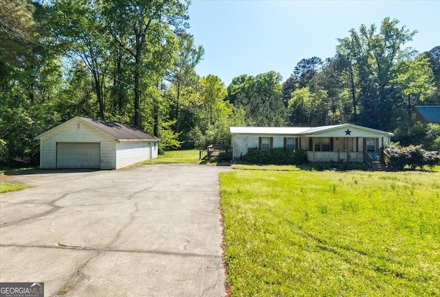 view of front of property featuring a garage, an outbuilding, a porch, and a front lawn
