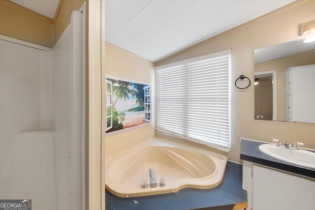 bathroom featuring vaulted ceiling, vanity, and a garden tub