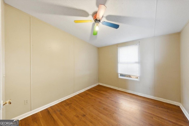 unfurnished room featuring ceiling fan, baseboards, and wood finished floors