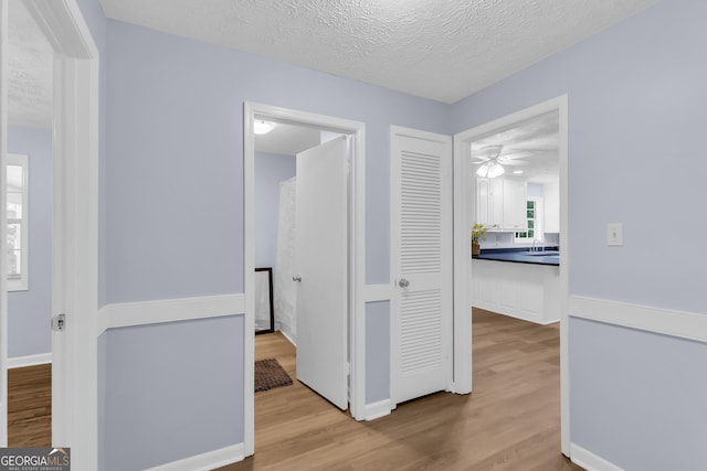 201 Oakdale Dr, Cornelia, GA 30531 - corridor with wood finished floors, a textured ceiling, and baseboards