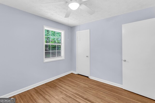 201 Oakdale Dr, Cornelia, GA 30531 - spare room with a textured ceiling, wood finished floors, baseboards, and a ceiling fan