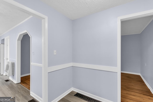 201 Oakdale Dr, Cornelia, GA 30531 - corridor with wood finished floors, baseboards, a textured ceiling, and arched walkways