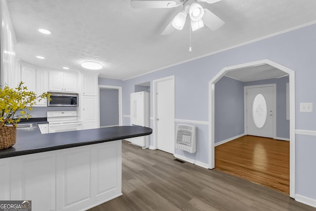 201 Oakdale Dr, Cornelia, GA 30531 - kitchen with white appliances, heating unit, dark countertops, a textured ceiling, and white cabinetry