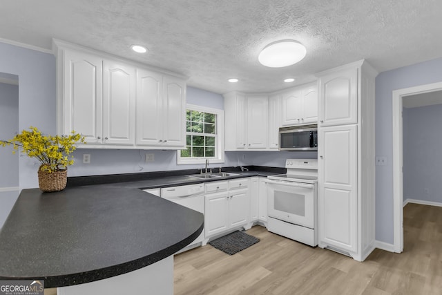 201 Oakdale Dr, Cornelia, GA 30531 - kitchen with white appliances, a sink, dark countertops, white cabinetry, and a peninsula