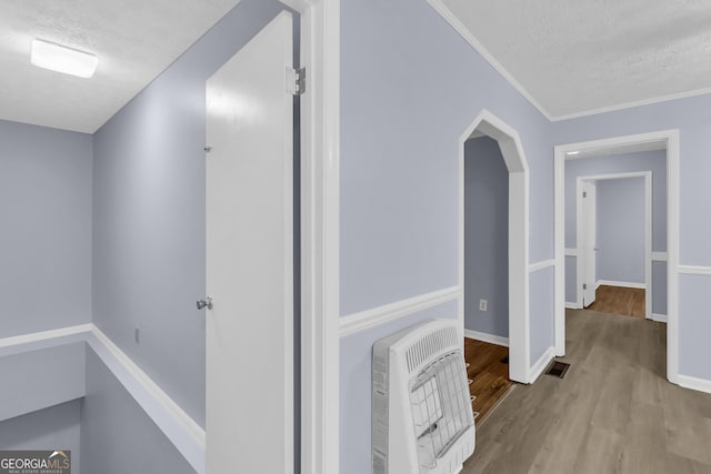 201 Oakdale Dr, Cornelia, GA 30531 - hall featuring heating unit, a textured ceiling, wood finished floors, baseboards, and ornamental molding