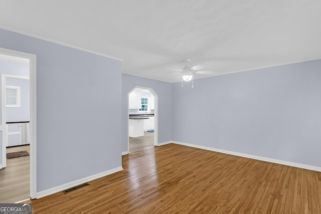 201 Oakdale Dr, Cornelia, GA 30531 - empty room featuring a ceiling fan, wood finished floors, baseboards, ornamental molding, and arched walkways