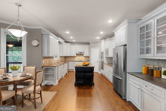 kitchen featuring decorative backsplash, appliances with stainless steel finishes, open shelves, light wood finished floors, and ornamental molding
