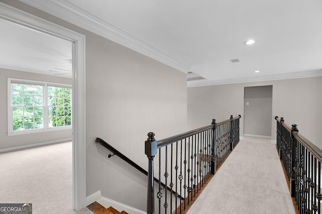 hall featuring carpet floors, an upstairs landing, and ornamental molding