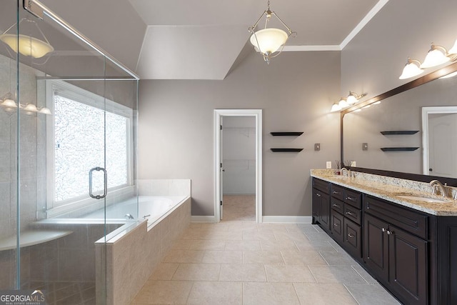 full bath with double vanity, a sink, a garden tub, and a stall shower
