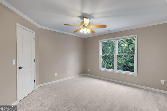 spare room with a ceiling fan, light colored carpet, visible vents, and baseboards