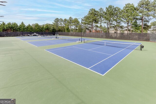 view of tennis court with fence and community basketball court