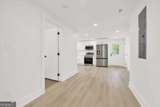 interior space featuring recessed lighting, baseboards, electric panel, and light wood-style flooring