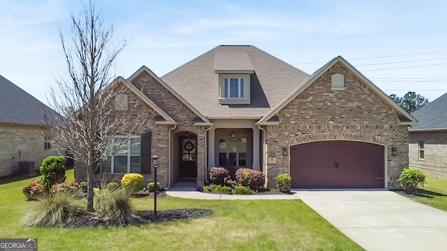 906 Abingdon Cv, Bonaire, GA 31005 - view of front of house with brick siding, driveway, a shingled roof, and a front lawn