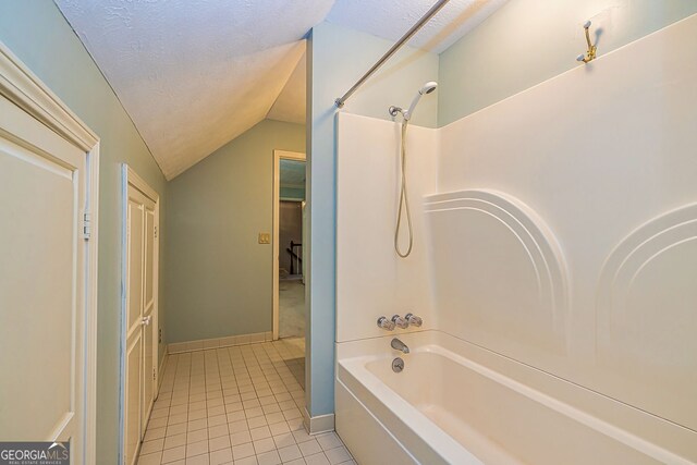 bathroom with vaulted ceiling, tile patterned flooring,  shower combination, baseboards, and a textured ceiling