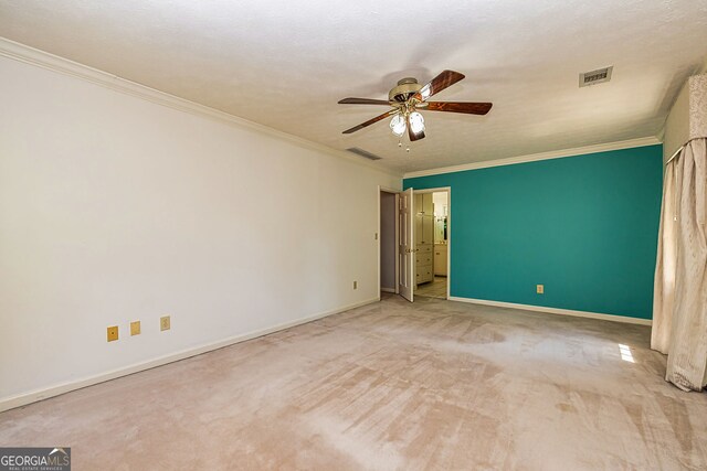 carpeted empty room featuring a ceiling fan, ornamental molding, and baseboards