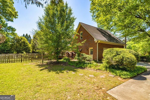 view of home's exterior with brick siding and a wooden deck