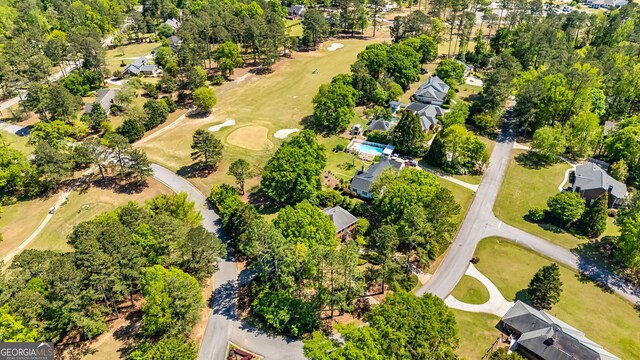 aerial perspective of suburban area featuring a tree filled landscape and a golf course