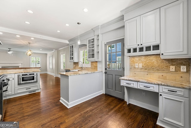 kitchen with a peninsula, backsplash, recessed lighting, a sink, and dark wood-style floors